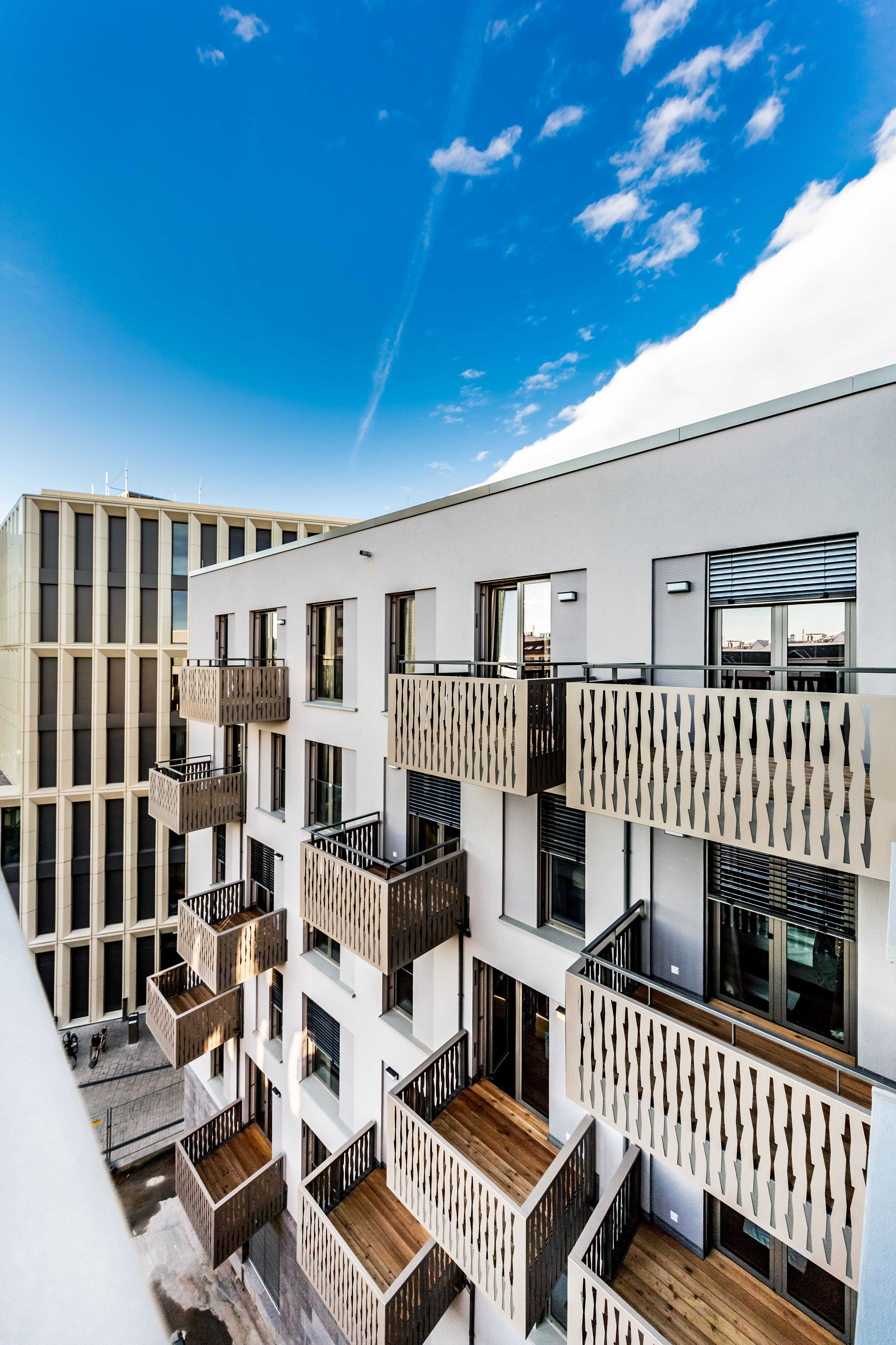 Moderne Hotel-Fassade mit stilvollen Balkonen unter blauem Himmel