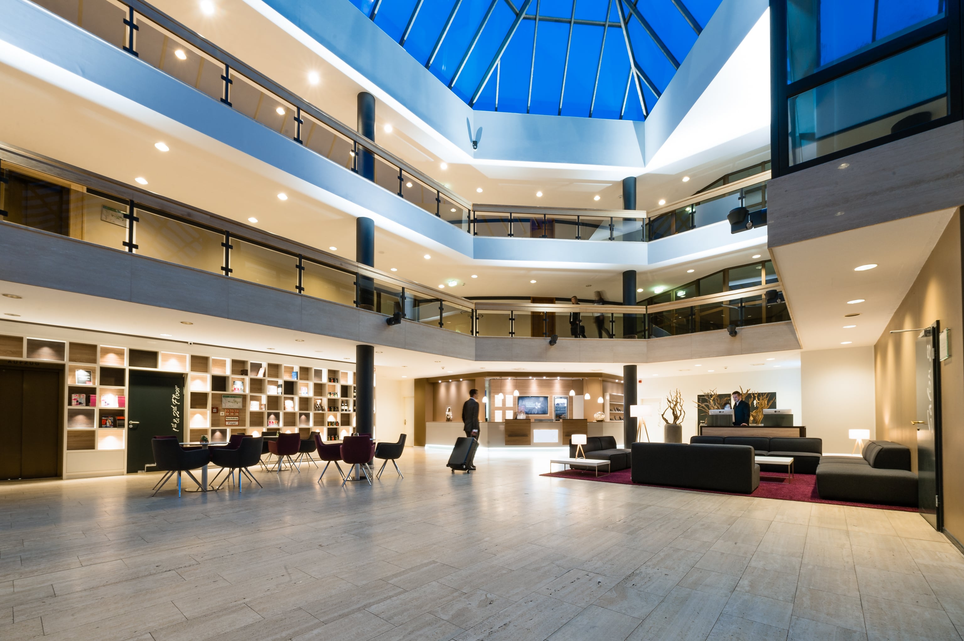 Modernes Hotel mit großzügiger Lobby, stilvollem Design und Glasdach für eine helle, einladende Atmosphäre